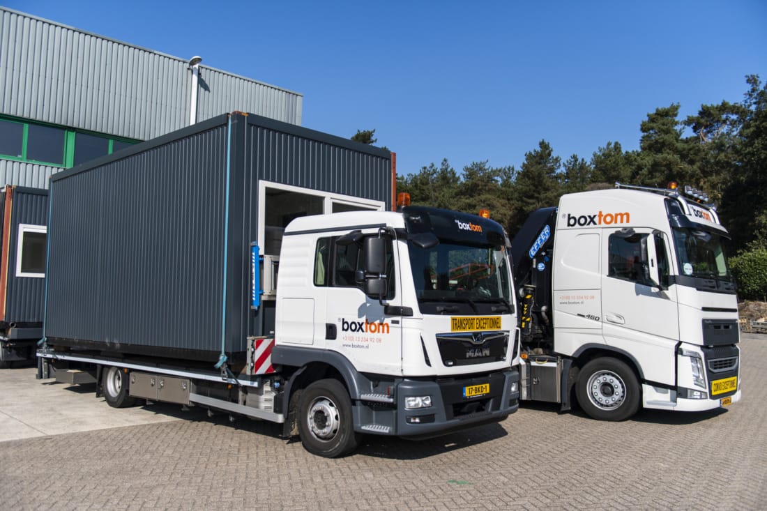 Transportwagens van Boxtom met woonunits die gebracht worden naar locatie.
