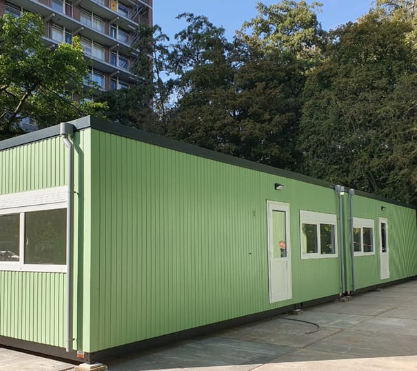 Groene wisselwoning in park voor huisvesting bewoners tijdens renovatieproject.